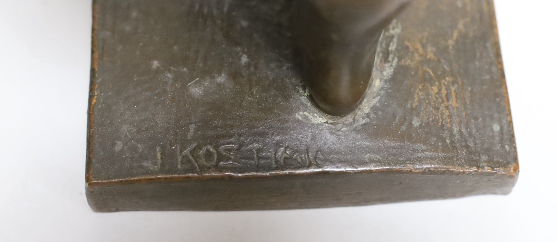 A bronze cherubic boy, signed J. Kostiak, 26cm high